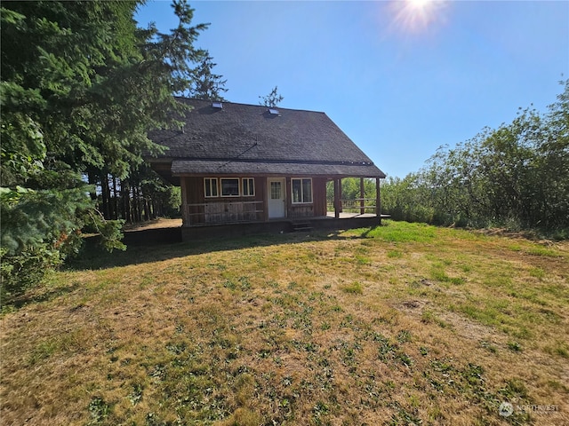 rear view of house featuring a lawn