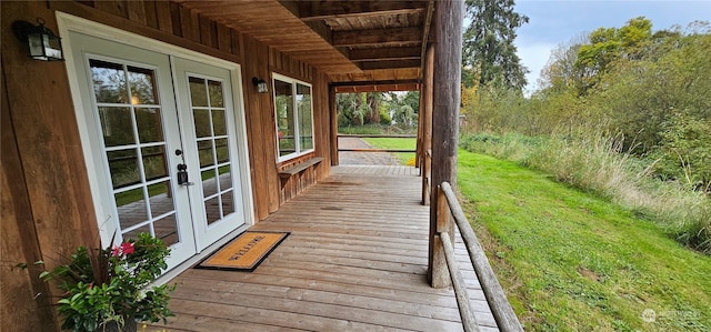 deck with french doors and a lawn