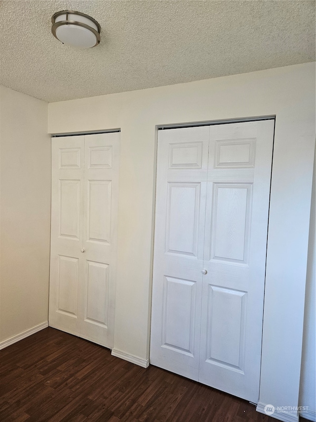 31003 14th Ave S Unit E-10, Federal Way, WA 98003 - unfurnished bedroom with dark wood-type flooring and a textured ceiling