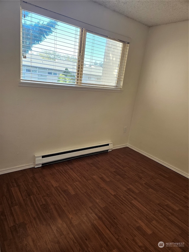 31003 14th Ave S Unit E-10, Federal Way, WA 98003 - empty room with a baseboard heating unit, dark hardwood / wood-style floors, and a textured ceiling