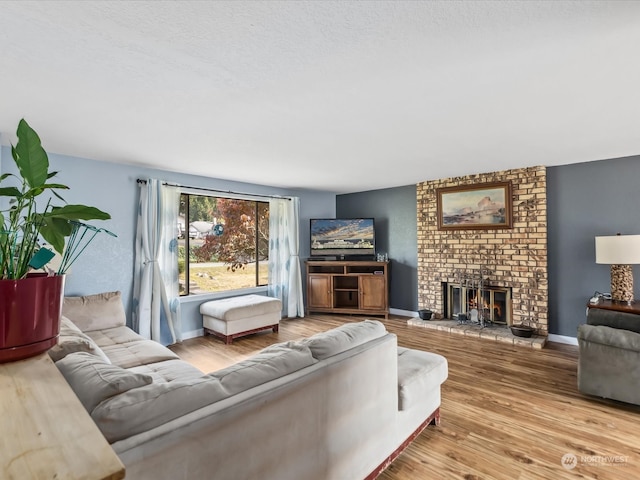 living room with a brick fireplace and hardwood / wood-style floors