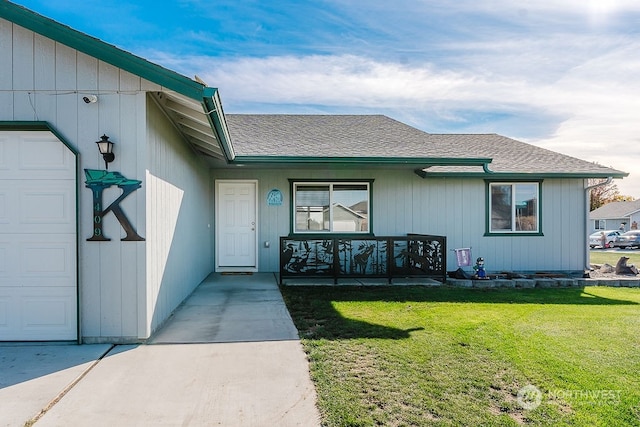 property entrance with a lawn and a garage