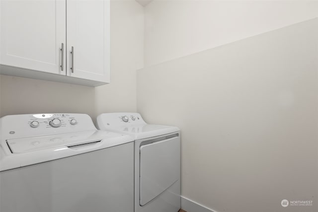 laundry room featuring washer and dryer and cabinets