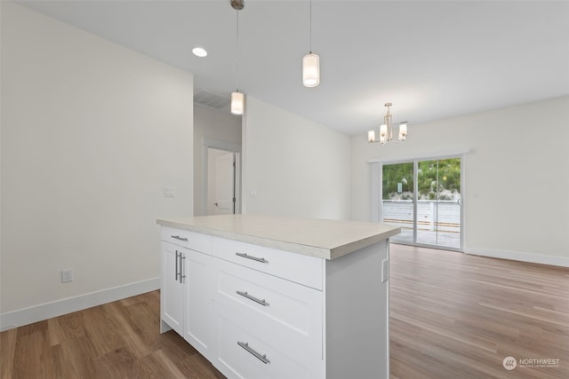 kitchen featuring a center island, pendant lighting, white cabinetry, a chandelier, and light hardwood / wood-style flooring