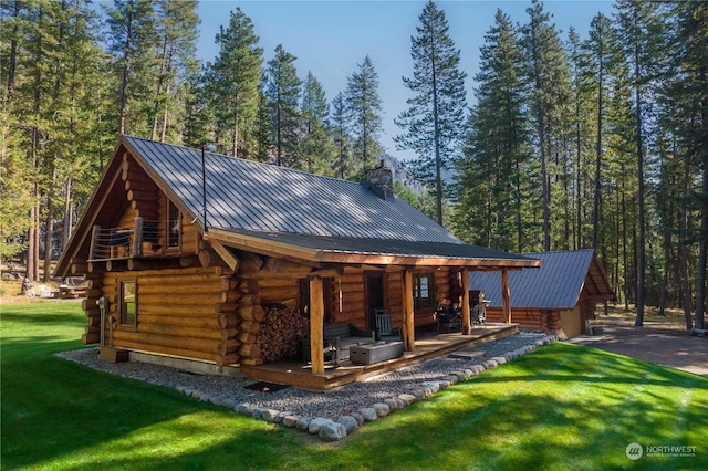 back of property featuring a lawn, a standing seam roof, log siding, and a chimney