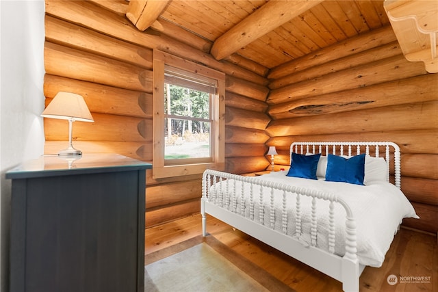 bedroom featuring beamed ceiling, hardwood / wood-style flooring, rustic walls, and wooden ceiling