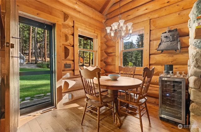 dining room featuring plenty of natural light, wine cooler, log walls, and light wood-type flooring