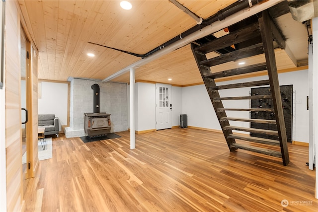 basement with a wood stove, hardwood / wood-style flooring, and wooden ceiling