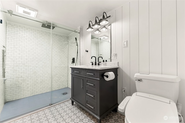 bathroom featuring vanity, a shower with shower door, and toilet