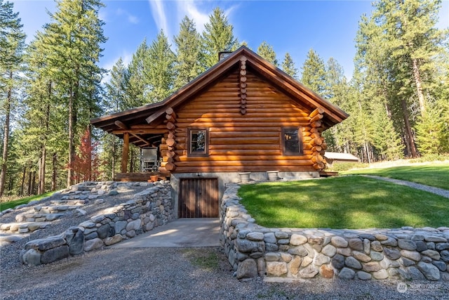 view of side of home with log siding and a yard