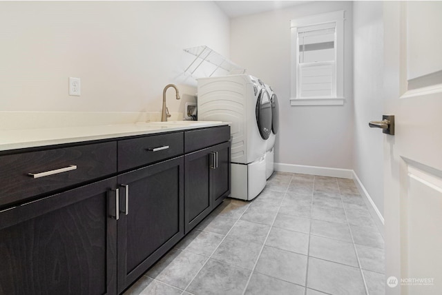 laundry area with light tile patterned flooring, cabinets, washer and clothes dryer, and sink