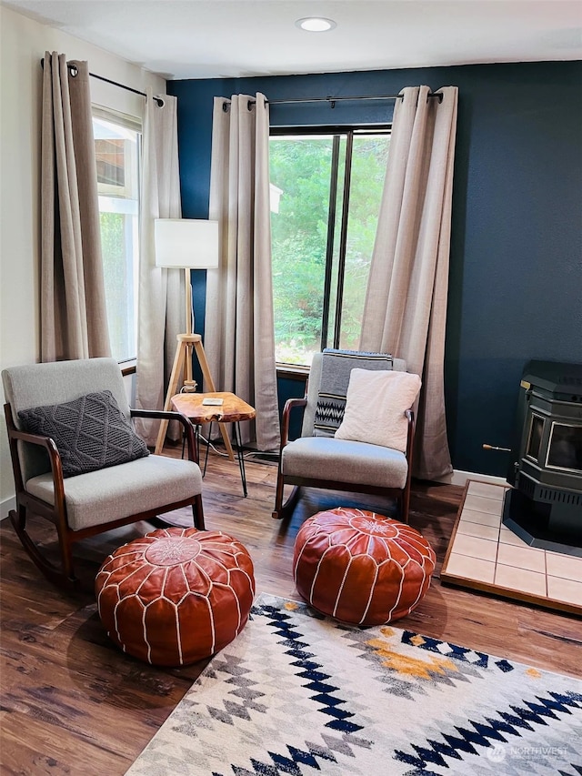 living area featuring wood-type flooring and a wood stove