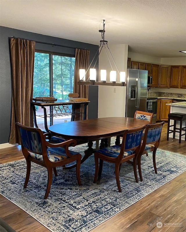 dining area with an inviting chandelier and dark wood-type flooring