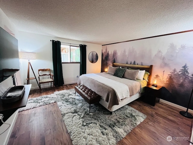 bedroom with dark hardwood / wood-style floors and a textured ceiling