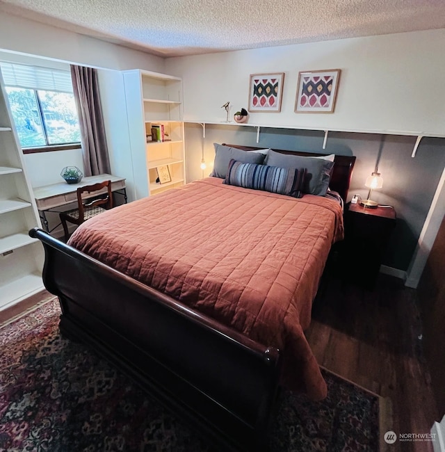 bedroom featuring wood-type flooring and a textured ceiling