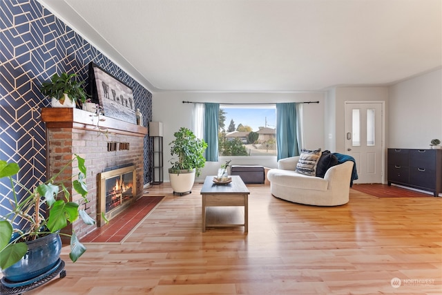 living room with a brick fireplace and light hardwood / wood-style flooring