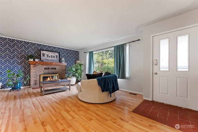 foyer with a brick fireplace and hardwood / wood-style floors