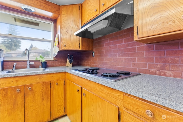 kitchen with white stovetop, sink, and tasteful backsplash