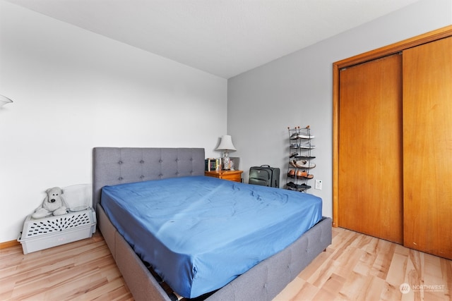 bedroom featuring pool table, a closet, and light hardwood / wood-style flooring