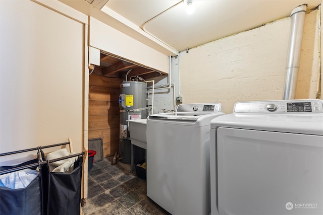 washroom with washing machine and dryer and strapped water heater