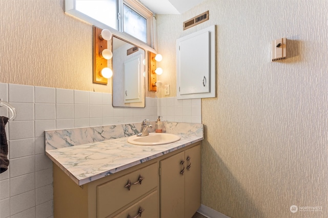 bathroom with vanity and tile walls