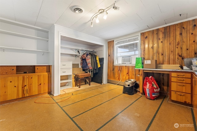 interior space featuring cooling unit, a closet, and wood walls