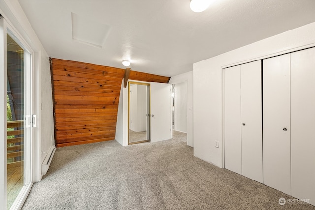 unfurnished bedroom featuring baseboard heating, a closet, and light colored carpet