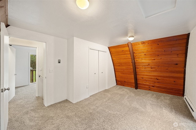 unfurnished bedroom featuring light carpet, a baseboard radiator, and a closet