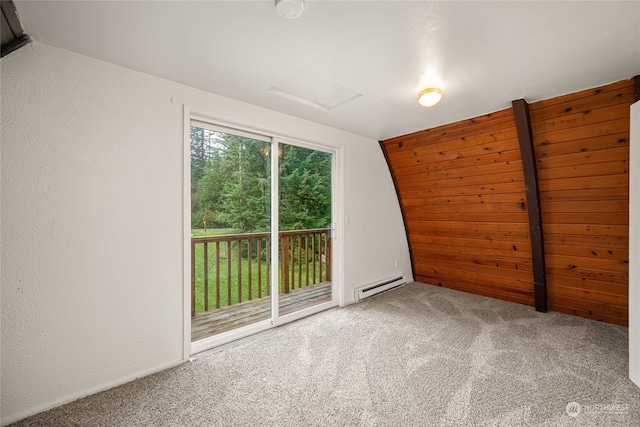 carpeted spare room with lofted ceiling and a baseboard heating unit