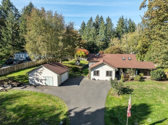 view of front of property featuring an outdoor structure, a garage, and a front lawn