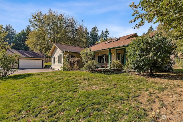 ranch-style home with a front yard, a garage, and an outbuilding