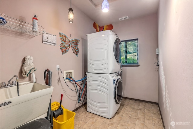 laundry room with stacked washer and clothes dryer and sink