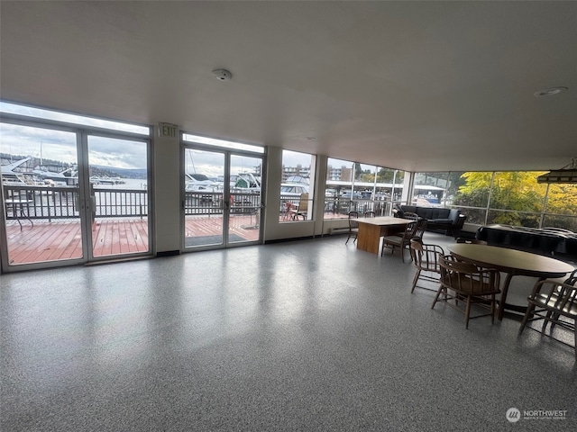 sunroom / solarium featuring a water view