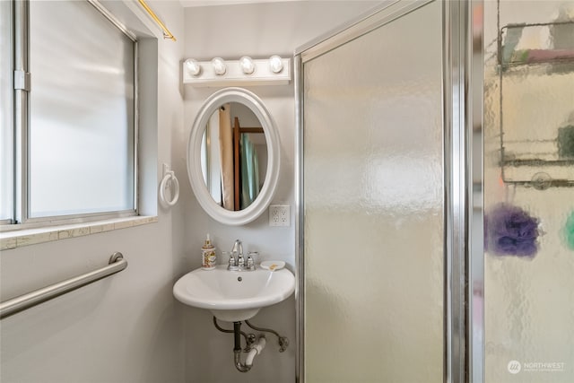 bathroom with sink and a shower with shower door