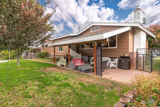 back of house with a lawn, fence, a chimney, and a patio area