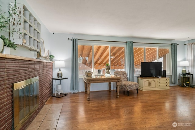 sitting room featuring a brick fireplace and hardwood / wood-style floors