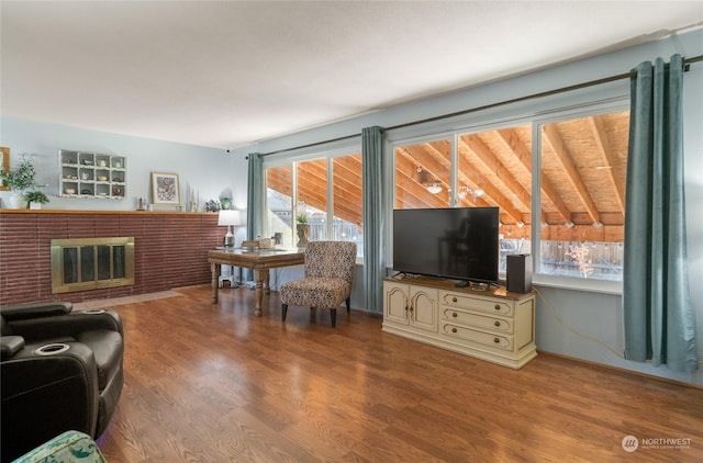 living room featuring a brick fireplace, a healthy amount of sunlight, and light hardwood / wood-style floors