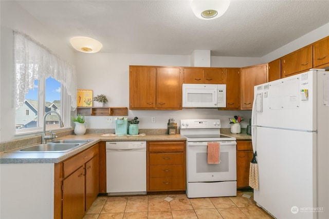 kitchen featuring light tile patterned flooring, white appliances, sink, and a textured ceiling