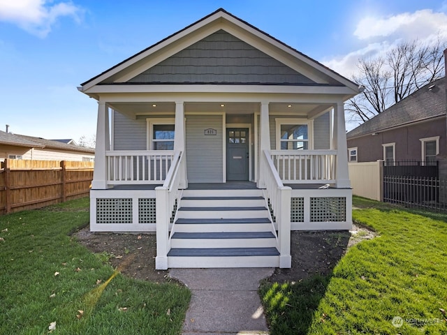 bungalow-style home with a front lawn and covered porch