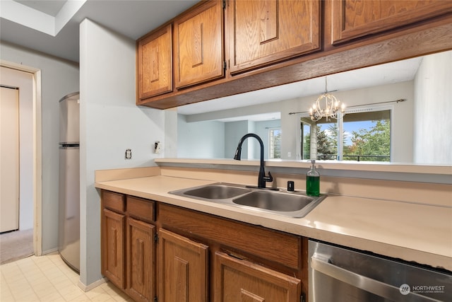 kitchen with stainless steel appliances, sink, a chandelier, and decorative light fixtures