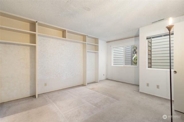 unfurnished bedroom with carpet flooring and a textured ceiling