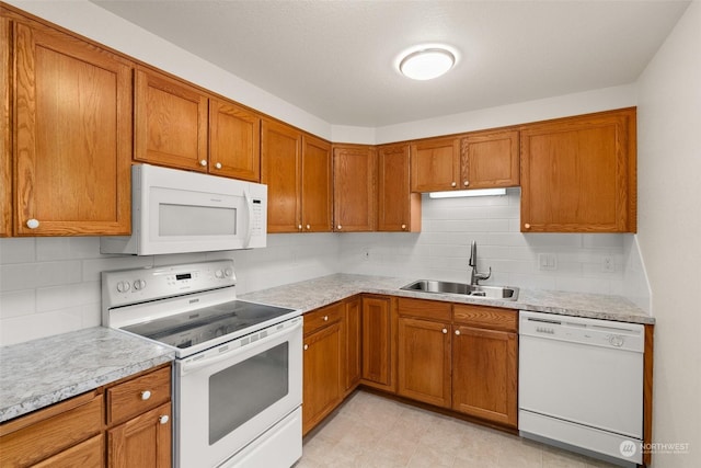 kitchen with tasteful backsplash, sink, and white appliances