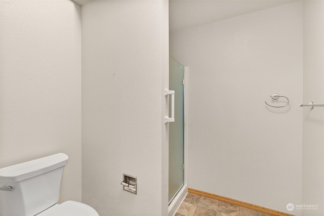 bathroom featuring walk in shower and toilet