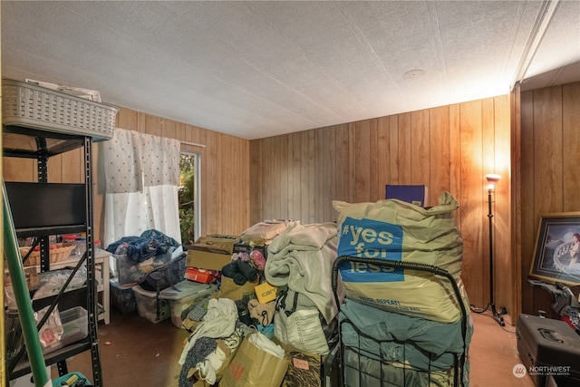 bedroom featuring a textured ceiling and wooden walls