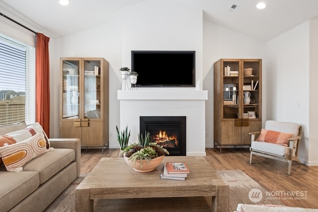 living room featuring hardwood / wood-style flooring and vaulted ceiling