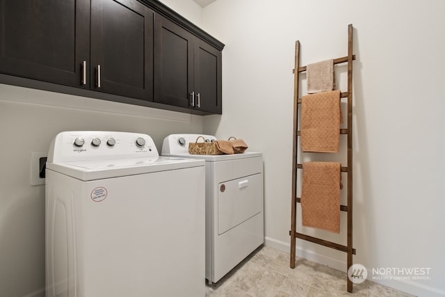 washroom with cabinet space, independent washer and dryer, and baseboards