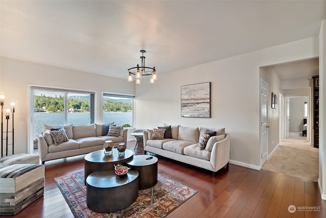 living room featuring a water view, a chandelier, and dark hardwood / wood-style floors