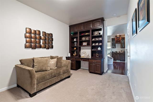 living area with light wood-type flooring and built in desk