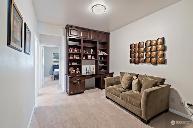 interior space featuring light colored carpet and built in desk