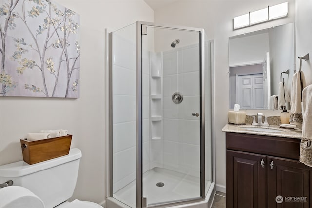 bathroom with tile patterned flooring, a shower with door, vanity, and toilet